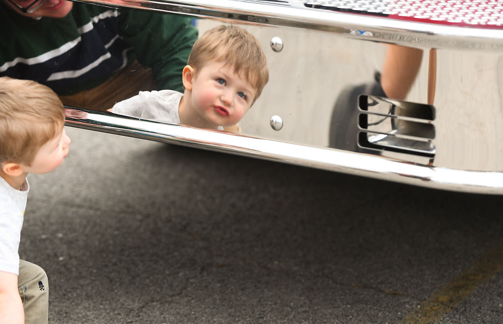 Silas Brunstrom, 2, stares at his reflection on a fire truck for the Sensory-friendly Touch-a-Truck event
